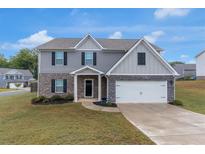 Charming two-story home with a combination brick and siding exterior and an attached two-car garage at 436 Vermeer Ct, Locust Grove, GA 30248