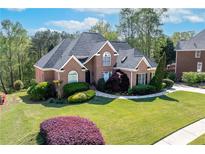 Beautiful brick home featuring lush landscaping and mature trees in a desirable neighborhood at 1450 Chadberry Way, Lawrenceville, GA 30043