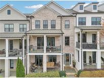 Beautiful townhome featuring brick facade, double balconies, and well-maintained landscaping at 115 Harlow Cir, Roswell, GA 30076