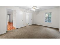 Bright bedroom features neutral carpet, white walls, and a ceiling fan for added comfort at 1606 Vicksburg Pl, Atlanta, GA 30350