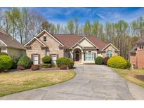 Charming single-story home with a brick facade, landscaped yard, and a curved driveway leading to a welcoming entrance at 2323 Council Ln, Buford, GA 30519