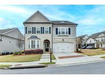 Charming two-story home featuring a two-car garage, a landscaped yard, and a mix of brick and siding exterior at 6585 Creekview Cir, Duluth, GA 30097