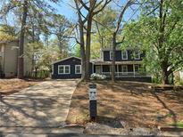 Charming two-story home with a dark gray exterior, white trim, and a welcoming front porch at 6921 Babbling Brook Dr, Rex, GA 30273