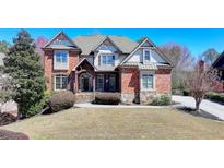 Stately brick and siding home with manicured lawn and mature landscaping at 2505 Weber Heights Way, Buford, GA 30519