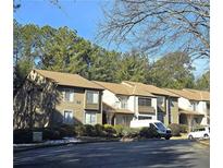View of the exterior of a multi-unit complex, featuring well-maintained landscaping and residential parking spaces at 315 Seasons Pkwy, Norcross, GA 30093
