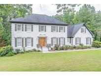 Charming two-story brick home featuring a well-manicured lawn and lush landscaping at 3442 Inns Brook Way, Snellville, GA 30039