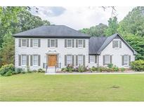 Charming two-story home with white brick exterior, gray shutters, and a lush green lawn at 3442 Inns Brook Way, Snellville, GA 30039