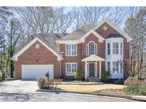 Charming two-story brick home featuring a manicured lawn and attached two-car garage at 1835 Berkeley Ne Mews, Atlanta, GA 30329