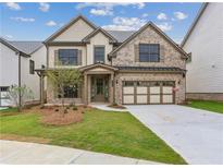 Charming brick-and-siding two-story home with an attached two-car garage and well-manicured lawn at 5817 Creek Indian Dr, Sugar Hill, GA 30518