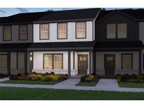 Charming two-story townhome featuring white siding, black trim, covered entryway and colorful landscaping at 2270 Ashton Dr, Conyers, GA 30013