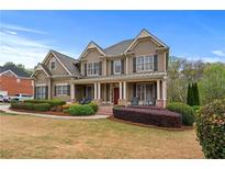 Charming two-story home with a manicured lawn and inviting front porch, perfect for relaxing and enjoying the outdoors at 3520 Millwater Xing, Dacula, GA 30019