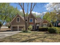 Charming home featuring a well-maintained lawn, a two-car garage, and tasteful landscaping at 2415 Carina Nw Ter, Acworth, GA 30101