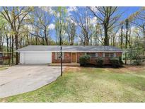 Charming single-story brick home featuring a well-maintained lawn and an attached two-car garage at 6175 Knights Ln, Douglasville, GA 30135