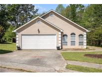 Charming single-story home with a two-car garage and a well-maintained front yard in a suburban setting at 165 Gingercake Ct, Fayetteville, GA 30214