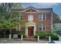 Charming two-story brick building featuring symmetric design, a red door, and manicured greenery at 733 Frederica Ne St # 12, Atlanta, GA 30306
