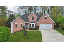 Beautiful two-story brick home with a well-manicured lawn and a two-car garage on a sunny day at 740 Trillium Ln, Lilburn, GA 30047