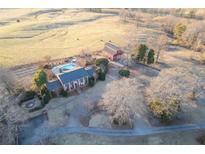 Expansive aerial view showcasing the home, pool, barn, and surrounding lush landscape at 1909 Hickory Level Rd, Villa Rica, GA 30180