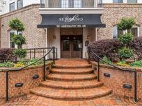 Inviting building entrance with brick steps, manicured landscaping and a black awning with white lettering at 901 Abernathy Ne Rd # 3200, Atlanta, GA 30328