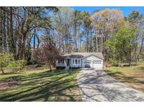 Charming single-story home with a well-manicured lawn and a two-car attached garage at 90 Chimney Rise Ct, Stockbridge, GA 30281