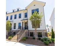Charming two-story townhouse with brick accents, landscaped yard, and a welcoming entrance staircase at 209 Phillips Ln, Alpharetta, GA 30009