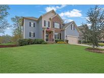 Charming two-story home with blue siding, brick accents, and a well-maintained lawn at 4040 Grandview Manor Dr, Cumming, GA 30028