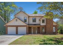 Charming two-story home featuring a brick facade, two-car garage, and well-maintained lawn at 10925 Pinehigh Dr, Alpharetta, GA 30022