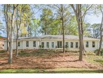 Charming single-story home with painted brick, multiple windows and a wooded lot creating a serene setting at 2729 Ridge Valley Nw Rd, Atlanta, GA 30327