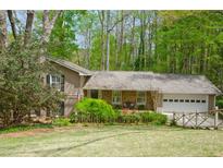 Charming single-Gathering home featuring a manicured front yard, stone accents, and an attached two-car garage at 4495 Glengary Ne Dr, Atlanta, GA 30342