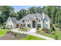 Stately brick home with manicured landscaping, circular driveway, and grand entrance, exuding curb appeal at 211 Meritage Dr, Alpharetta, GA 30022