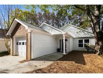Charming single-story home featuring a one-car garage and cozy front porch, nestled amid mature trees and landscaping at 309 Elizabeth Blvd, Alpharetta, GA 30009