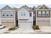 Charming townhome featuring a one-car garage and neutral siding at 6179 Centennial Run, Atlanta, GA 30349