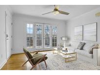 Bright living room features hardwood floors, ceiling fan, and French doors to the balcony at 869 Briarcliff Ne Rd # B11, Atlanta, GA 30306
