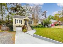 Charming home featuring a well-manicured lawn, inviting front porch, and convenient garage at 51 Willow Wood Se Cir, Atlanta, GA 30317