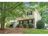 Charming two-story home with stone accents and lush greenery in a well-maintained front yard at 1019 James Madison Ct, Mcdonough, GA 30253