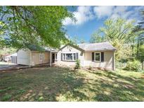 Charming single-story home featuring a quaint front yard and a mix of trees and natural light at 2194 Ivydale St, Atlanta, GA 30344