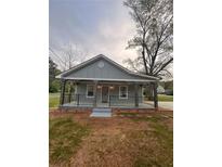 Charming home featuring a welcoming front porch with stone supports and wrought iron railing at 4321 Austell Powder Springs Sw Rd, Powder Springs, GA 30127