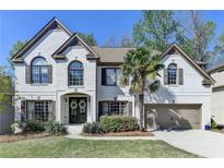 Charming two-story brick home with a well-manicured lawn and a beautiful palm tree at 6770 Ulster Ct, Alpharetta, GA 30005