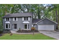 Charming two-story home with gray brick exterior and well-manicured front lawn at 9415 Martin Rd, Roswell, GA 30076
