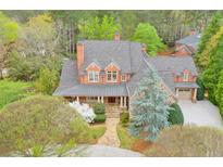 Charming two-story home with stone and brick exterior and well-manicured landscaping at 800 Flathead Pass, Suwanee, GA 30024