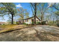 Charming one-story home with light siding, wood accents, mature trees, and a spacious yard at 4980 W Chapel Hill Rd, Douglasville, GA 30135