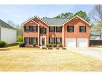 Charming two-story brick home featuring an attached two-car garage and meticulously maintained landscaping at 3903 Cain Mill Dr, Lithonia, GA 30038