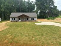 New construction home featuring a freshly installed lawn and a charming covered porch at 482 West Ave, Bowdon, GA 30108