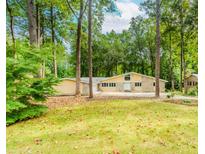 Inviting single-story home featuring stone accents, ample windows, and a lush front lawn with mature trees at 247 Old Timber Rd, Lawrenceville, GA 30046