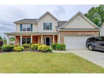 Charming two-story home featuring a manicured lawn, brick accents, and a two-car garage at 3285 Watson Gate Rd, Loganville, GA 30052