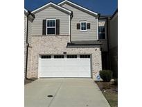 Charming two-story home with a two car garage and neutral brick and vinyl siding at 950 Sunny Lake Dr, Lawrenceville, GA 30043
