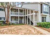 Condo exterior with multiple units, gray siding, white trim, and landscaping at 66 Fair Haven Se Way, Smyrna, GA 30080