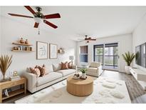 Bright living room features hardwood floors, ceiling fan, and sliding glass doors to outdoor balcony at 66 Fair Haven Se Way, Smyrna, GA 30080