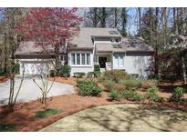 Charming home featuring a well-manicured lawn with mature landscaping and a two-car garage at 80 Seville Chase, Atlanta, GA 30328