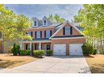 Charming two-story brick home with a well-manicured lawn and a two-car garage at 3285 Pebble Ridge Ln, Buford, GA 30519