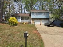 Charming two-story home with stone accents, attached two-car garage, front porch, and blossoming shrub at 3657 Willow Wood Way, Lawrenceville, GA 30044